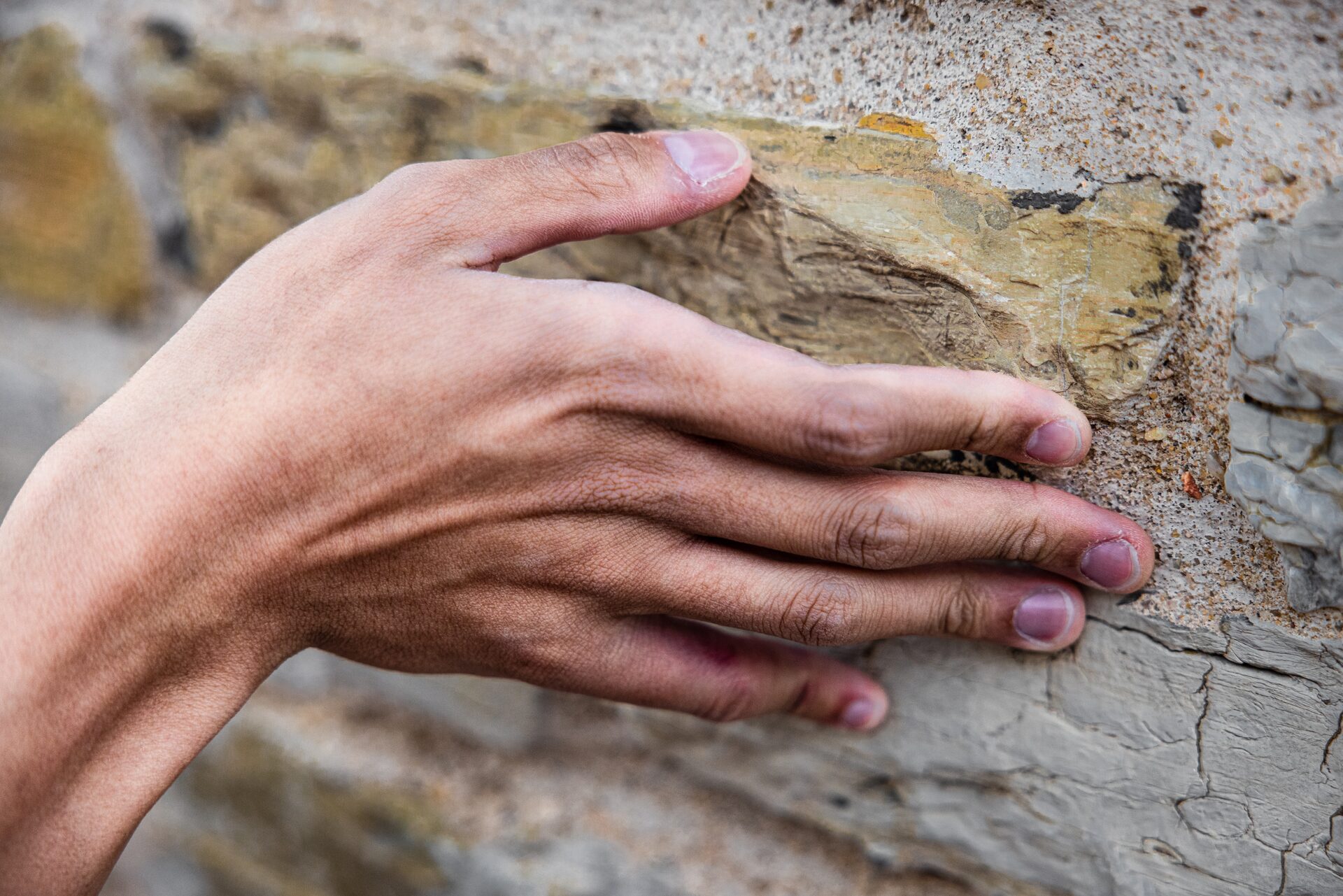 Hand touching Bentheimer sandstone surface